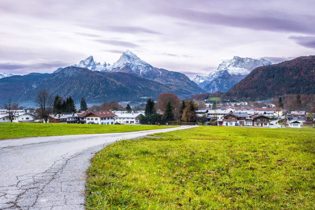 Green meadow, Berchtesgadener town and Watzmann mountain on a background. Bavarian alps. Germany